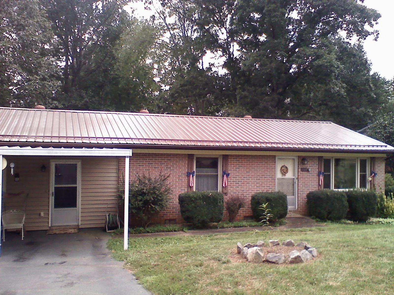 Bronze metal roof and carport on a brick ranch home — Roof Repair work by our crew in Voorheesville